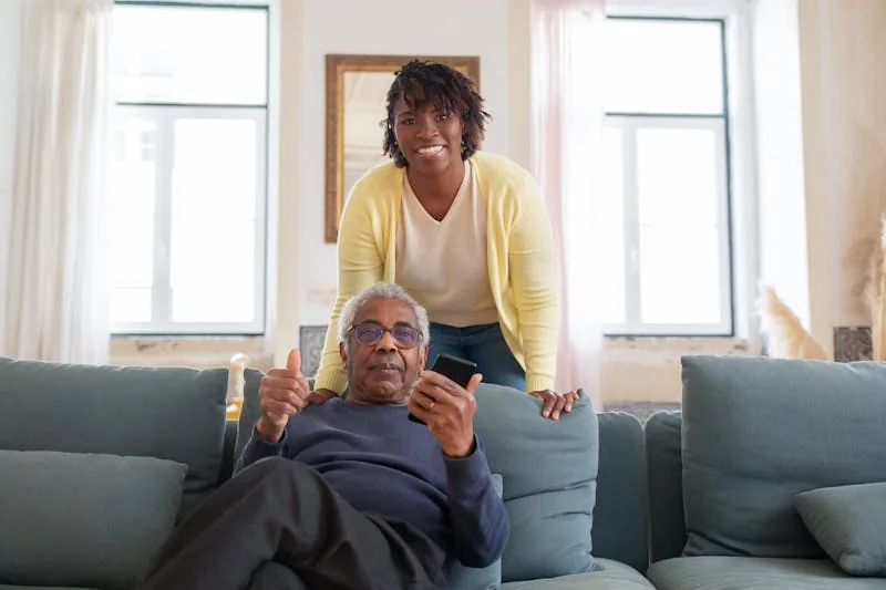 Carer and elderly person using mobile phone app together at home