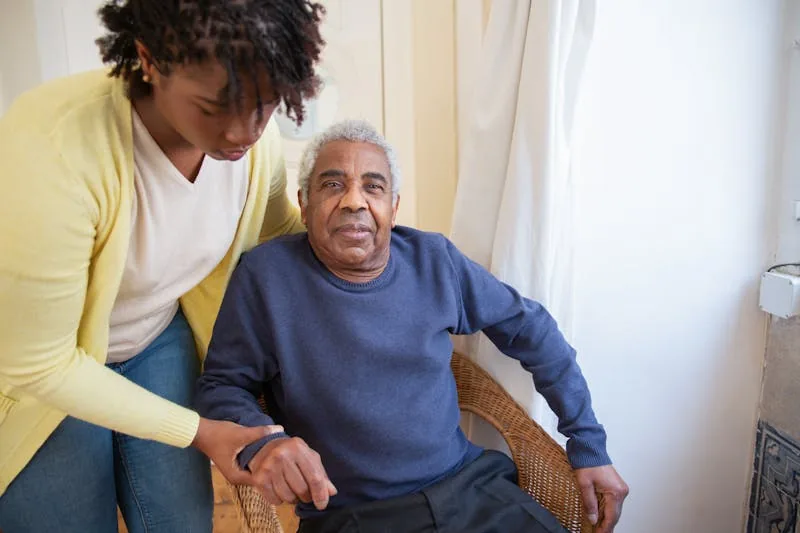 Carer providing compassionate support to an elderly gentleman at home