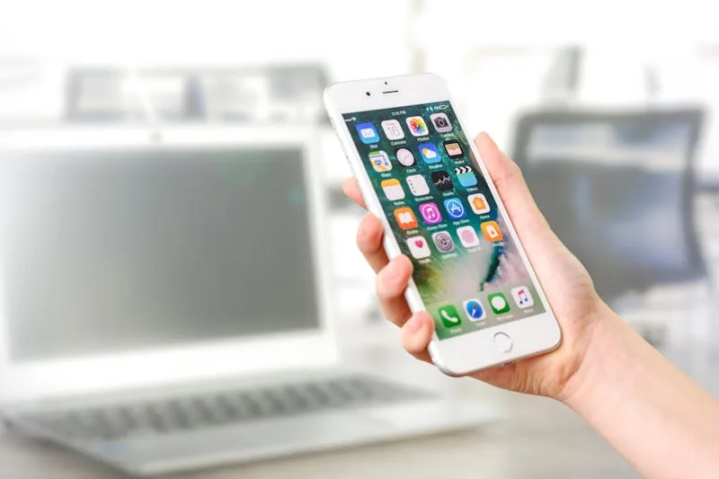 A hand holding a phone showing a home care visit on a mobile app