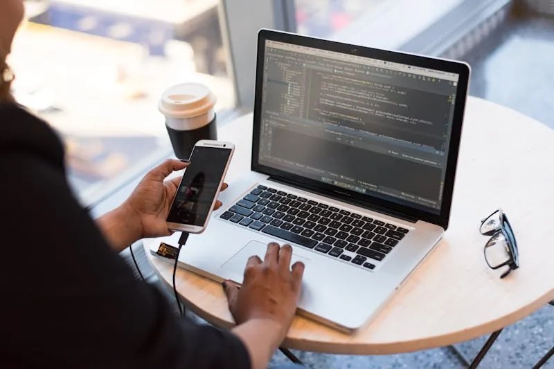 Person working on laptop and phone managing care agency operations